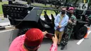 Warga berfoto dengan kendaraan taktis TNI yang dipamerkan di depan Istana Merdeka, Jakarta, Senin (4/10/2021). Ratusan alat utama sistem persenjataan (Alutsista) TNI dipamerkan sepanjang pinggir jalan sekeliling kawasan Monas dalam rangka peringatan HUT ke-76 TNI. ​(merdeka.com/Arie Basuki)