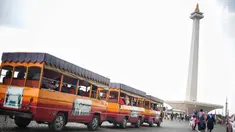 Kereta wisata membawa pengunjung mengelilingi kawasan Monumen Nasional (Monas), Jakarta, Sabtu (22/12). Libur sekolah yang berbarengan dengan libur Natal dan Tahun Baru dimanfaatkan masyarakat untuk pergi berwisata ke Monas. (Liputan6.com/Faizal Fanani)