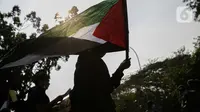 Peserta yang tergabung dalam Jerit Palestina membawa bendera Palestina saat menggelar aksi di depan Kedubes Amerika Serikat, Jakarta, Jumat (7/5/2021). Dalam aksinya mereka mendesak Amerika Serikat untuk menarik bantuan kepada Israel dalam penjajahan Palestina. (Liputan6.com/Faizal Fanani)