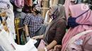 Pedagang menggunakan alat pelindung wajah (Face Shield) saat berjualan di Kawasan Tanah Abang, Jakarta, Senin (18/5/2020). Penggunaan alat pelindung wajah itu sebagai upaya untuk melindungi diri saat berhubungan dengan pembeli dalam pecegahan penyebaran COVID-19. (Liputan6.com/Faizal Fanani)