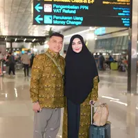 Anang dan Ashanty resmi bertolak ke Tanah Suci untuk menunaikan ibadah haji melalui Bandara Soekarno-Hatta, Tangerang. Ashanty pun mengenakan kerudung panjang hitam dengan outer seragam motif batik. [@ashanty_ash]