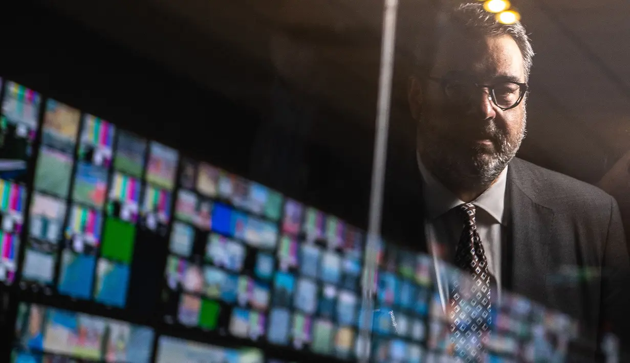 Yiannis Exarchos, CEO Olympic Broadcasting Services (OBS), terlihat di jendela saat ia berpose untuk foto setelah wawancara dengan AFP di studio OBS, International Broadcast Center (IBC), Tokyo pada 28 Juli 2021. selama Olimpiade Tokyo 2020.
(AFP/Philip Fong)