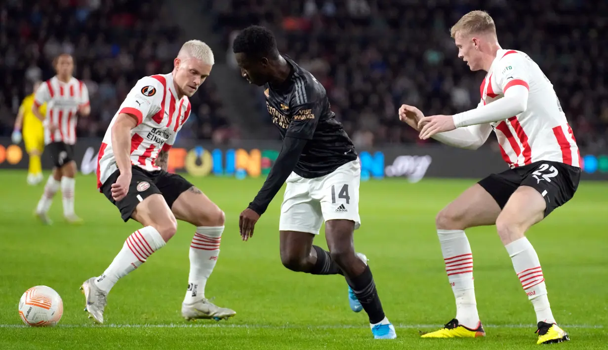 Pemain Arsenal Eddie Nketiah (tengah) menggiring bola melewati pemain PSV Eindhoven Philipp Max (kiri) dan Jarrad Branthwaite pada pertandingan sepak bola Grup A Liga Europa di Stadion Philips, Eindhoven, Belanda, 27 Oktober 2022. Arsenal kalah 0-2 dari PSV Eindhoven. (AP Photo/Peter Dejong)