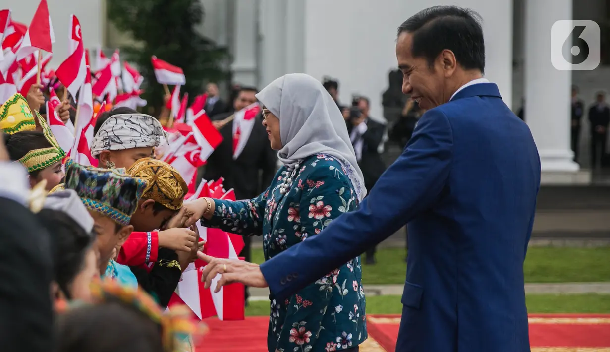 Presiden Joko Widodo (kanan) bersama Presiden Singapura, Halimah Yacob menyapa anak-anak berbaju daerah saat penyambutan kenegaraan di Istana Bogor, Jawa Barat, Selasa (4/3/2020). Halimah datang ke Indonesia bersama suaminya Mohamed Abdullah Alhabshee. (Liputan6.com/Faizal Fanani)