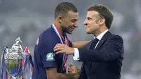 Pemain PSG, Kylian Mbappe (kiri) bersalaman dengan Presiden Prancis, Emmanuel Macron saat upacara penyerahan trofi Coupe De France 2023/2024 di Stade Pierre-Mauroy, Villeneuve-d'Ascq, Prancis, Minggu (26/05/2024) WIB. PSG menang dengan skor 2-1 atas Olympique Lyon pada babak final. (AP Photo/Michel Euler)