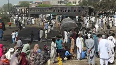 Warga berkumpul di dekat lokasi kecelakaan antara kereta penumpang dengan kereta tangki minyak di Distrik Sheikhupura, Punjab, Selasa (28/3). Sedikitnya dua orang termasuk masinis kereta tewas dalam kejadian tersebut. (AFP Photo / Ludovic Marin)