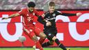 Penyerang Bayern Munchen, Serge Gnabry, berebut bola dengan pemain Bayer Leverkusen, Daley Sinkgraven, pada laga Bundesliga di Stadion BayArena, Minggu (20/12/2020). Bayern Munchen menang dengan skor 2-1. (Bernd Thissen/Pool Photo via AP)
