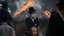 Pria dan anak-anak Yahudi Ultra-Ortodoks membakar beragi sebagai persiapan liburan Paskah di kota Yahudi ultra-Ortodoks Bnei Brak, Tel Aviv, Israel (26/3/2021). Dalam perayaan ini umat Yahudi dilarang memakan makanan beragi seperti roti tawar. (AP Photo/Oded Balilty)