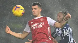 Gelandang Arsenal, Granit Xhaka (kiri) berebut bola dengan gelandang West Bromwich Albion, Romaine Sawyers dalam laga lanjutan Liga Inggris 2020/21 pekan ke-17 di Hawthorns Stadium, Sabtu (2/1/2021). Arsenal menang 4-0 atas West Bromwich Albion. (AFP/Michael Regan/Pool)