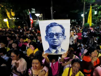 Rakyat Thailand membawa gambar Raja Thailand Bhumibol Adulyadej di luar RS Siriraj, Bangkok, Thailand, Kamis (13/10). (REUTERS / Jorge Silva)