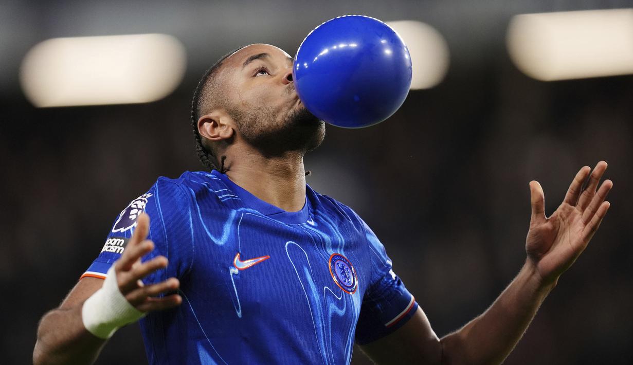 Pemain Chelsea, Christopher Nkunku melakukan selebrasi dengan meniup balon setelah mencetak gol ke gawang Southampton dalam laga lanjutan Liga Inggris 2024/2025 di Stamford Bridge, London, Rabu (26/02/2025) WIB. (AP Photo/John Walton)