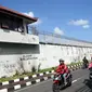 Pengendara sepeda motor melintas di samping bangunan Lembaga Pemasyarakatan (Lapas) Kerobokan, Bali, Senin (19/6). Empat narapidana asing kabur melalui lubang sepanjang 15 meter yang mengarah ke parit di luar bangunan Lapas. (SONNY TUMBELAKA/AFP)