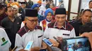 Cagub dan cawagub Kalimantan Timur Syaharie Jaang dan Awang Ferdian Hidayat menjawab pertanyaan wartawan usai penetapan oleh KPU Kaltim di Samarinda, Senin (12/2). Pasangan ini diusung oleh Demokrat, PKB, dan PPP. (Liputan6.com/Maulana)