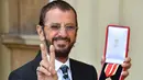Ringo Starr berpose di Istana Buckingham, di London, Inggris (20/3). Mantan drummer The Beatles ini mendapat gelar kebangsawanan dari Pangeran William. Ia diberi gelar 'Sir' atas jasanya dalam dunia musik. (John Stillwell / Pool Photo via AP)