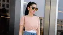 Seperti ini misalnya, Angel tampak kece dengan celana ripped jeans dan crop top berwarna peach. Gayanya makin menarik lantaran Angel memakai kacamata hits dan heels berwarna khakinya. (Instagram/realangelkaramoy)