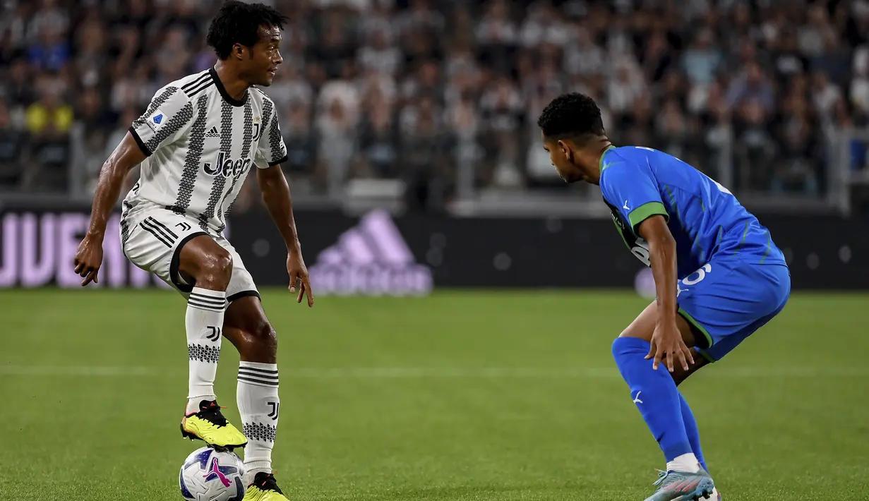 <p>Gelandang Juventus, Juan Cuadrado (kiri) mengontrol bola dari kawalan pemain Sassuolo, Rogerio berebut bola selama pertandingan pertandingan Liga Serie A Italia di stadion Juventus di Turin (15/8/2022). Juventus menang atas Sassuolo 3-0. (Marco Alpozzi/LaPresse via AP)</p>