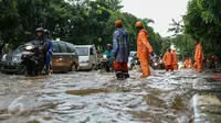 Petugas PPSU Srengseng Sawah melakukan pengaturan kendaraan yang melintas di jalan Lenteng Agung, Jakarta, (12/2). Akibat Hujan deras,  jalan Lenteng Agung tepat di depan Universitas Pancasila  tergenang banjir hingga 50 cm. (Liputan6.com/Yoppy Renato)