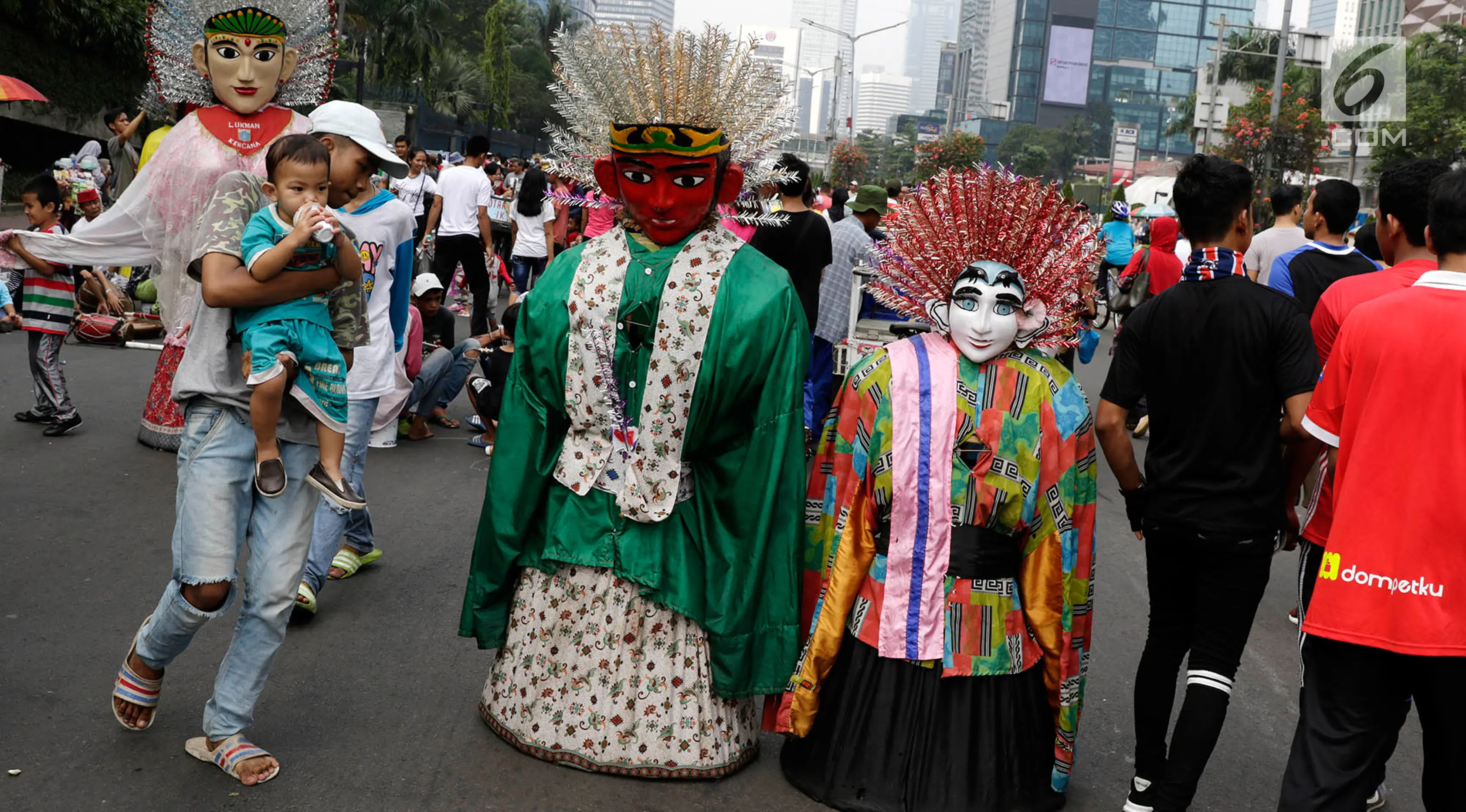 Pengamen ondel-ondel meminta sumbangan kepada warga di lokasi car free day, Jakarta, Minggu (21/5). Ramainya pengunjung CFD menyebabkan banyak pengamen mencari rezeki di kegiatan yang berlangsung setiap minggu tersebut. (Liputan6.com/Immanuel Antonius)