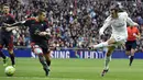 Pemain Real Madrid, Gareth Bale melakukan tembakan ke arah gawang Celta de Vigo saat dihadang para pemain lawan pada lanjutan La Liga Spanyol di Stadion Santiago Bernabeu , Madrid, Sabtu (5/3/2016). (AFP/Gerard Julien)