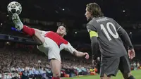 Gelandang Arsenal, Declan Rice (kiri), berusaha memertahankan bola dari jangkauan pemain Real Madrid, Luka Modric, pada leg 1 perempat final Liga Champions 2024/2025 di Emirates Stadium, Rabu (9/4/2025) dini hari WIB. (AP Photo/Frank Augstein)