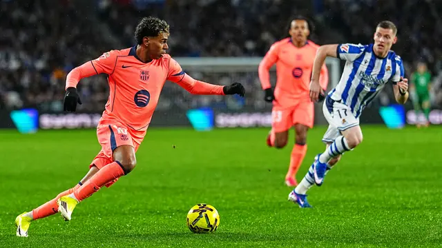 Pemain Barcelona Lamine Yamal (kiri) beraksi pada laga La Liga/Liga Spanyol antara Real Sociedad vs Barcelona