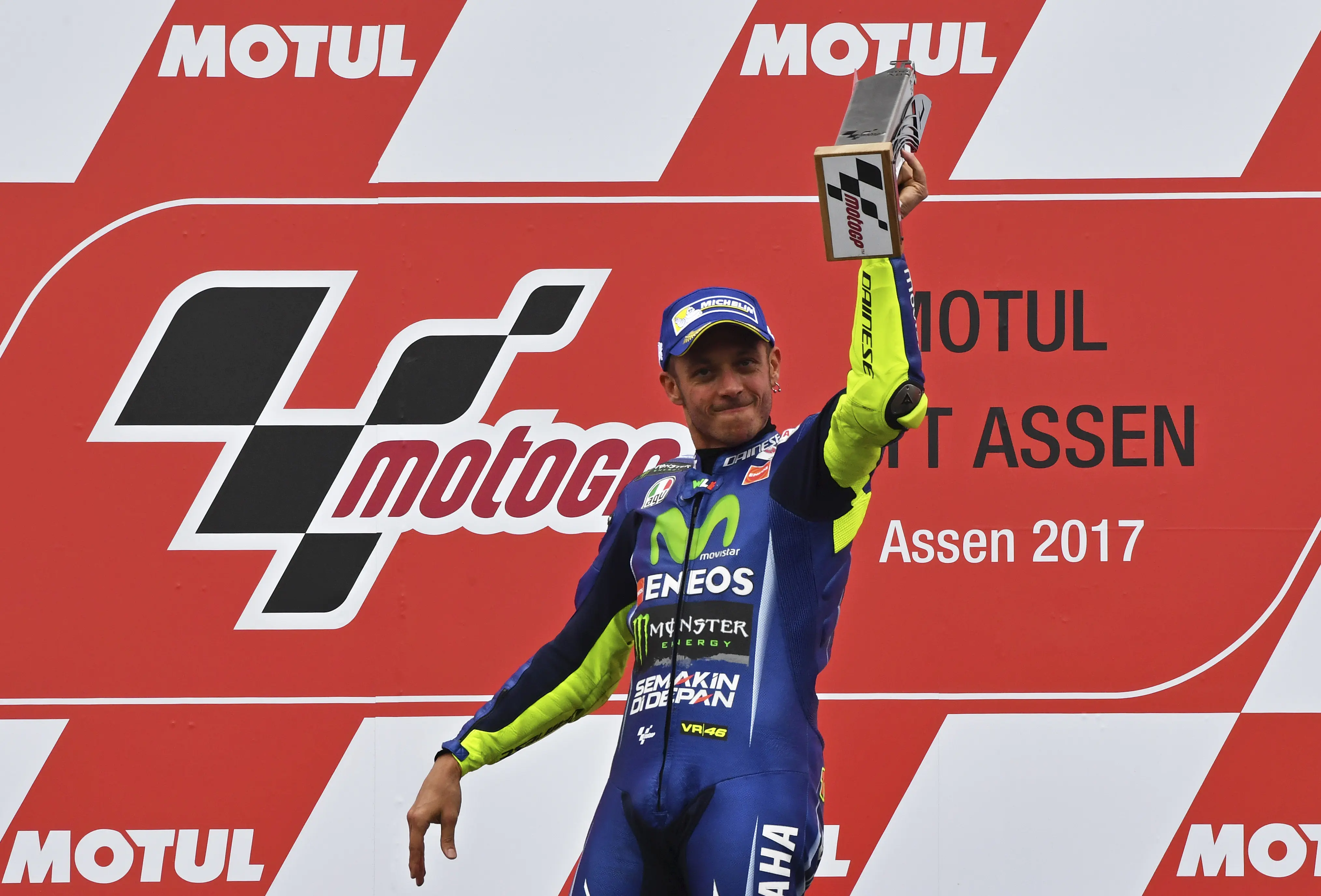 Senyum bahagia pembalap Movistar Yamaha, Valentino Rossi saat naik podium juara MotoGP Belanda 2017. (AP Photo/Geert Vanden Wijngaert)