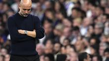 Pelatih Manchester City, Pep Guardiola, tertunduk setelah tim asuhannya kalah 1-3 dari Real Madrid pada leg kedua play-off 16 besar Liga Champions 2024/2025 di Santiago Bernabeu, Kamis (20/2/2025) dini hari WIB. (AP Photo/Manu Fernandez)