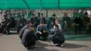 Sejumlah pria Korea Utara berbincang di luar supermarket di pusat kota Pyongyang, Korea Utara, (21/10).  (AP Photo / Dita Alangkara)