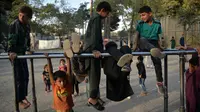 Anak-anak bermain pada palang besi yang terpasang di Shahr-e Naw Park, Kabul, Afghanistan, 9 September 2021. Taliban menguasai Afghanistan setelah pasukan Amerika Serikat meninggalkan negara tersebut. (HOSHANG HASHIMI/AFP)