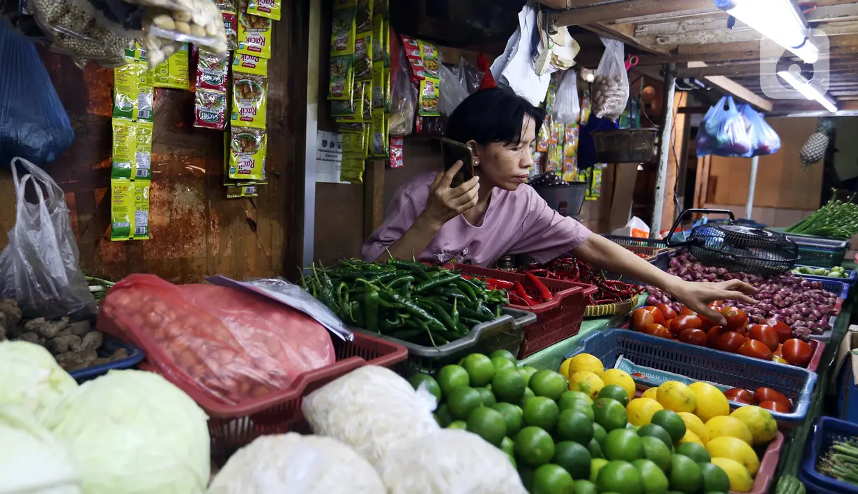 Wahyuning menata kebutuhan pokok dagangannya di Pasar Pondok Labu, Jakarta, Rabu, (8/6/2022). Wahyuning menjelaskan harga cabai merah tembus Rp 80.000 per kilogram dari yang sebelumnya Rp 40.000, diikuti cabai rawit dan bawang merah. (Liputan6.com/Johan Tallo)