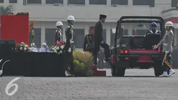 Presiden Joko Widodo menaiki mobil untuk memeriksa pasukan dalam upacara HUT Bhayangkara Polri ke-69 di Jakarta, Rabu (1/7/15). Upacara HUT Bhayangkara Polri ke-69 dihadiri Presiden Joko Widodo sebagai inspektur upacara. (Liputan6.com/Herman Zakharia)