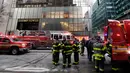 Kendaraan dan para petugas pemadam berada di lokasi kebakaran di Fifth Avenue, depan Trump Tower, di New York, Senin (8/1). Kebakaran yang mengakibatkan dua orang luka-luka tersebut berasal dari pendingin di bagian atas gedung. (AP Photo/Richard Drew)