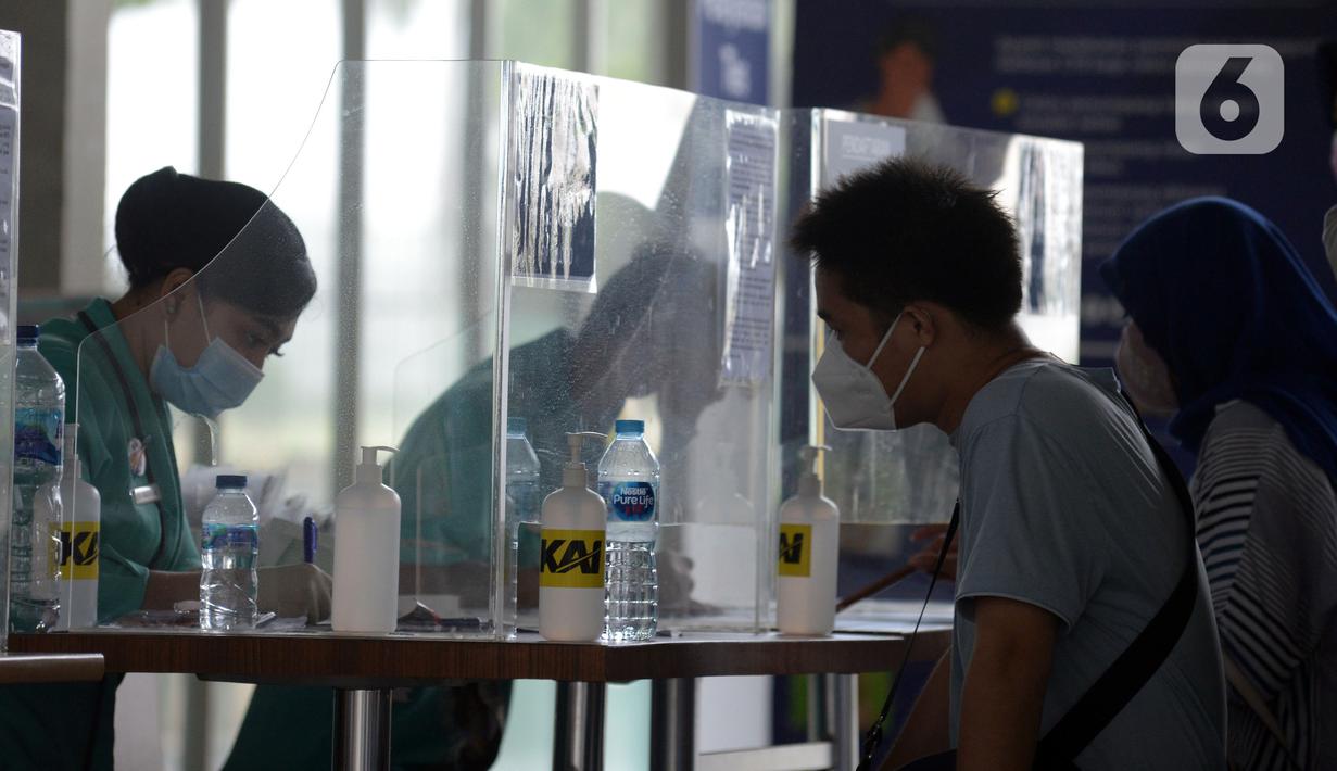 Petugas mendata calon penumpang saat dilakukan tes COVID-19 dengan GeNose C19 di Stasiun Pasar Senen, Jakarta, Selasa (23/2/2021). Hasil tes tersebut kemudian menjadi dokumen syarat perjalanan para penumpang kereta. (merdeka.com/Imam Buhori)