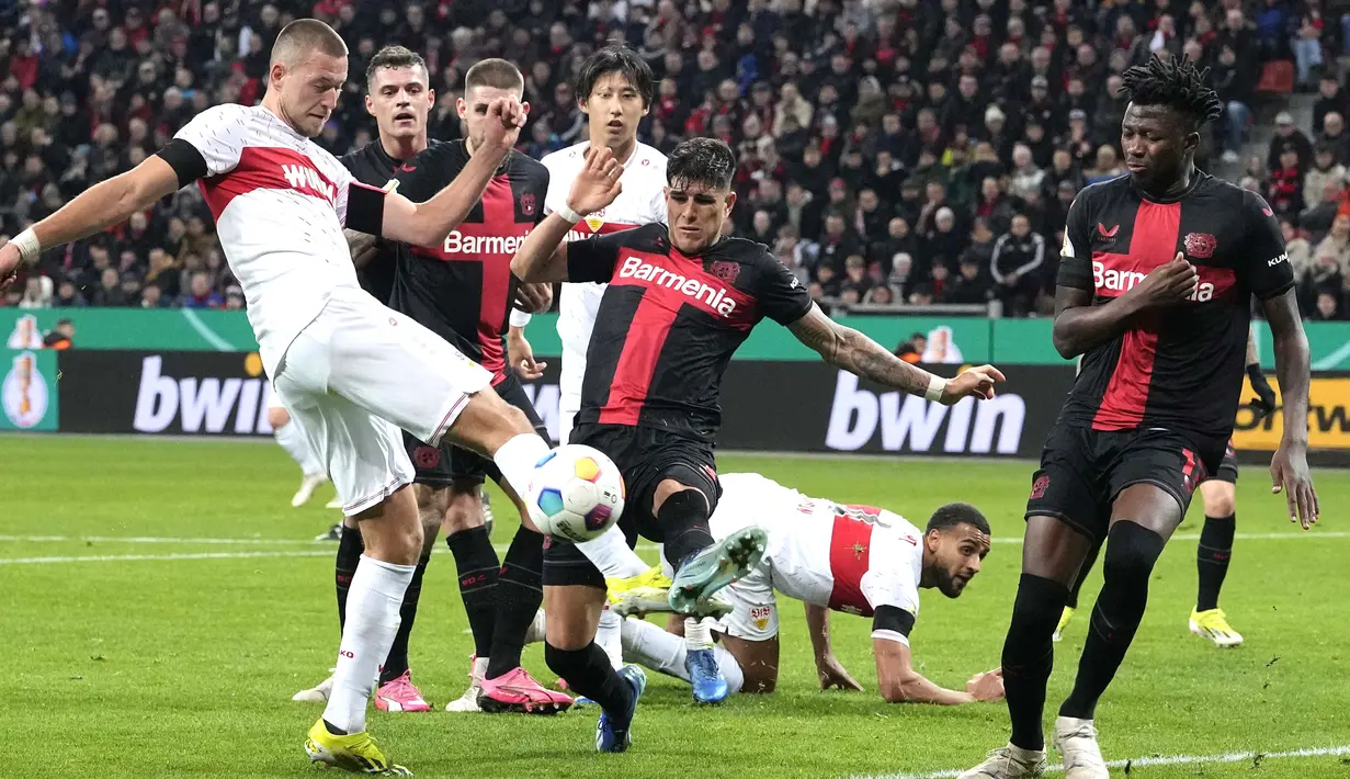 Pemain Bayer Leverkusen, Piero Hincapie, berusaha mengadang tendangan pemain Stuttgart, Waldemar Anton pada laga perempat final DFB Pokal di Stadion di BayArena, Rabu (7/2/2024). (AP Photo/Martin Meissner)