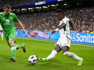 Penyerang Real Madrid Vinicius Junior berebut bola dengan bek Real Betis Sokratis Papastathopoulos pada pekan ke-38 (pekan terakhir) La Liga 2023/2024 di Santiago Bernabeu, Minggu (26/5/2024). (AP Photo/Manu Fernandez)