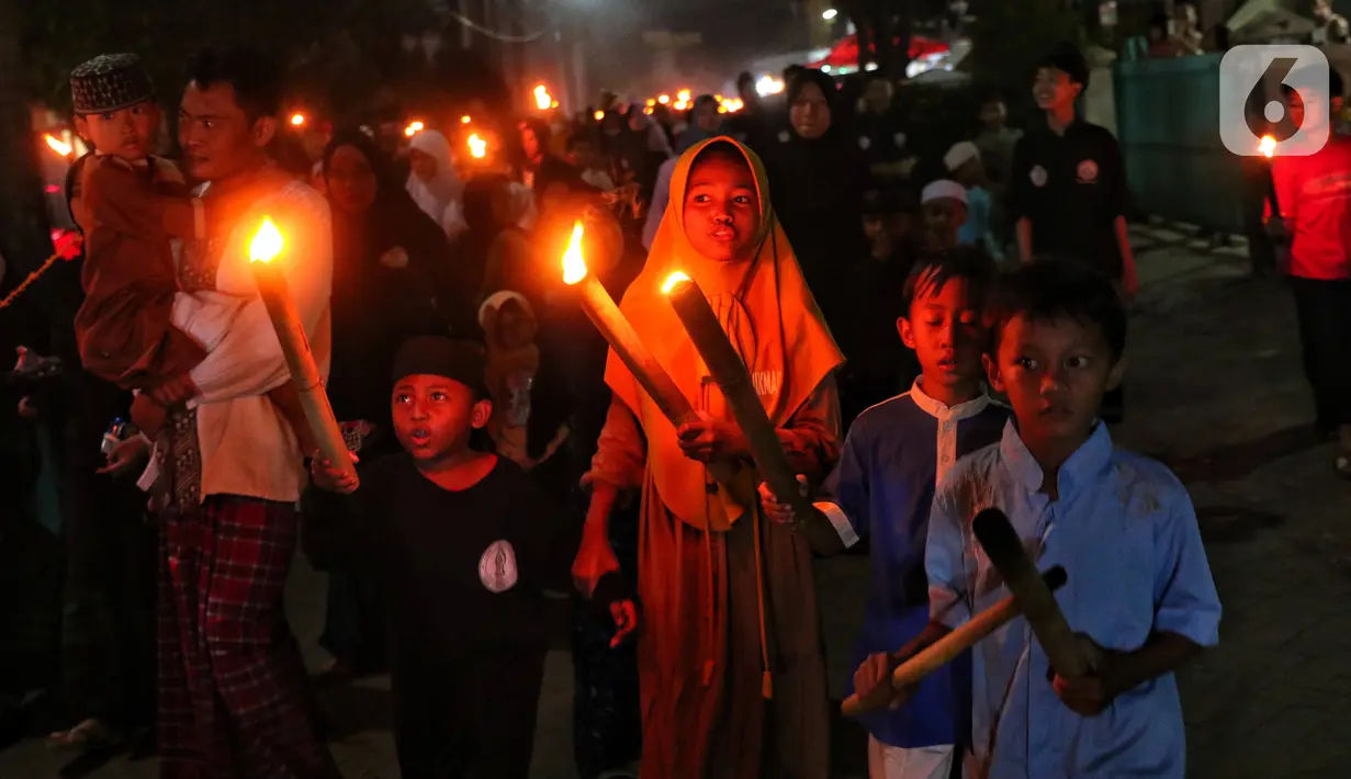 Anak-anak membawa obor sambil berkeliling kampung di kawasan Kota Tangerang, Banten, Jumat (29/7/2022) malam. Pawai obor tersebut digelar untuk menyambut malam pergantian Tahun Baru Islam atau 1 Muharam 1444 H. (Liputan6.com/Angga Yuniar)