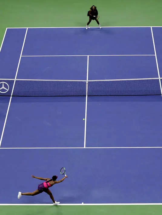 Petenis Venus Williams (bawah) mengembalikan bola kepada adiknya, Serena Williams (atas) selama putaran ketiga turnamen tenis AS Terbuka, di New York, Jumat (31/8). Venus kalah dari Serena. (AP Photo/Julio Cortez)