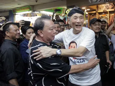 Bakal calon gubernur DKI Jakarta dari Partai Golkar  Jusuf Hamka alias Babah Alun mencoba kaus dengan gambar wajahnya bertuliskan "Baba Alun for Jakarta" saat blusukan ke Pasar Tanah Abang Blok A, Jakarta, Kamis (1/8/2024). (Liputan6.com/Herman Zakharia)