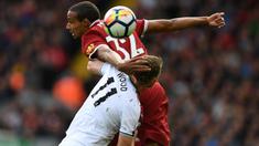 Pemain Liverpool, Joel Matip (kiri) berduel dengan pemain Burnley, Chris Wood pada lanjutan Premier League pekan kelima di Anfield Stadium, Liverpool (16/9/2017). Liverpool bermain imbang 1-1.  (AFP/Paul Ellis)