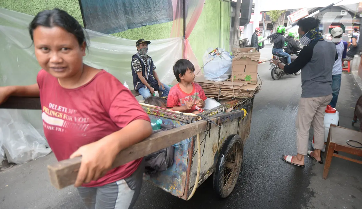 Sejumlah pemuda menyemprotkan cairan disinfektan kepada orang yang akan memasuki RW 10 di kawasan Tanah Kusir, Kelurahan Kebayoran Lama Selatan, Jakarta, Rabu (8/4/2020). Warga menerapkan akses satu pintu masuk pemukiman tersebut untuk mencegah penyebaran corona COVID-19. (merdeka.com/Dwi Narwoko)