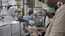 Pedagang melayani pembeli masker di toko alat kesehatan di Pasar Pramuka, Jakarta, Selasa (4/2/2020). Isu merebaknya wabah virus corona di Indonesia membuat penjualan masker di Pasar Pramuka meningkat pesat meski dalam sepekan harga melonjak tajam. (merdeka.com/Iqbal Nugroho)