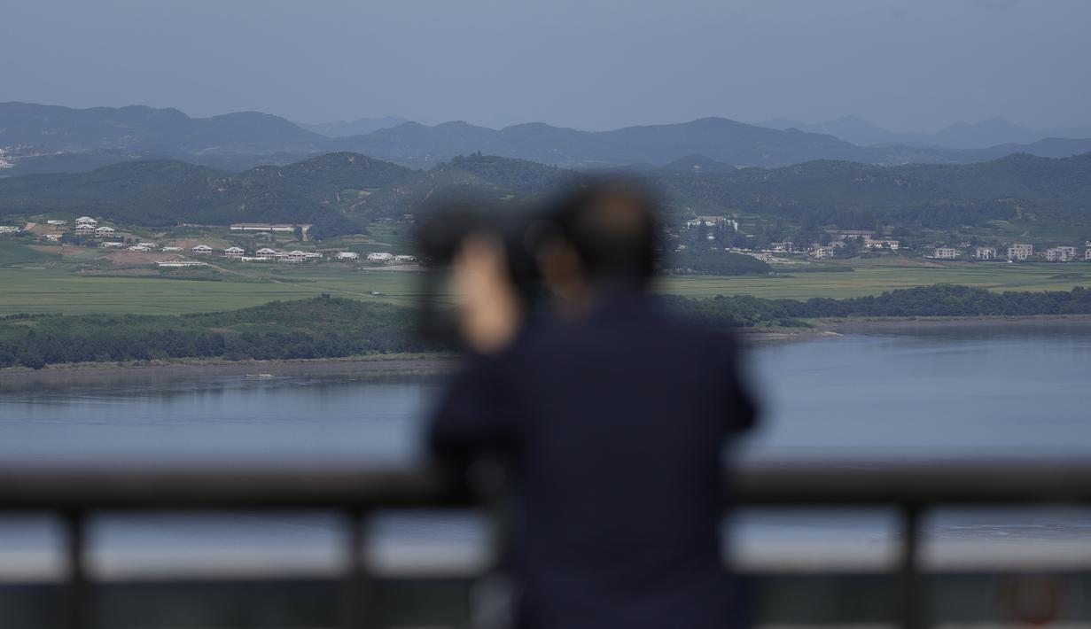 Seorang pengunjung menggunakan teropong untuk melihat sisi Korea Utara dari observatorium unifikasi di Paju, Korea Selatan, Kamis (8/9/2022). Terpisah puluhan tahun, warga dari dua Korea tidak mengetahui apakah kerabat mereka masih hidup atau tidak. (AP Photo/Lee Jin-man)