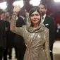 Malala Yousafzai yang mengenakan kerudung sequin perak berpose di karpet merah Oscar 2023. (dok. Emma McIntyre / GETTY IMAGES NORTH AMERICA / Getty Images via AFP)
