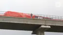 Petugas mengecek kereta ringan lintas rel terpadu (LRT) Jabodebek yang mengalami kecelakaan di jalur lintas LRT Cibubur, Jakarta Timur, Senin (25/10/2021). Dua kereta LRT tersebut sedang uji coba saat tabrakan terjadi sehingga gerbong kosong. (Liputan6.com/Herman Zakharia)