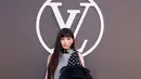 Hyein NewJeans bergaya industrial kenakan jumpsuit abu-abu dengan boots kulit. Sentuhan scarf polkadot dengan tiered ruffles jadi aksen playful [LouisVuitton]