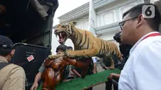 Petugas menyita Harimau Sumatera yang diawetkan (offset) saat penggeledahan terhadap rumah tersangka penodongan pelajar SMA menggunakan senjata api, Abdul Malik di kawasan Kemang, Kamis (26/12/2019). Polres Jakarta Selatan menyita empat hewan langka yang sudah dibekukan. (merdeka.com/Imam Buhori)