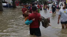 Seorang nenek digendong saat melintasi banjir yang menggenangi Jalan KH Hasyim Ashari, Tangerang, Banten, Kamis (2/1/2020). Banjir yang menggenangi jalan penghubung Jakarta- Tangerang tersebut mulai surut dan sudah bisa dilintasi pejalan kaki. (Liputan6.com/Angga Yuniar)