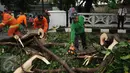 Petugas Damkar PB dibantu warga memotong bagian pohon yang tumbang di Jalan Kemang Raya, Jakarta, Sabtu (7/11/2015). Tidak ada korban dalam peristiwa ini. (Liputan6.com/Helmi Fithriansyah)