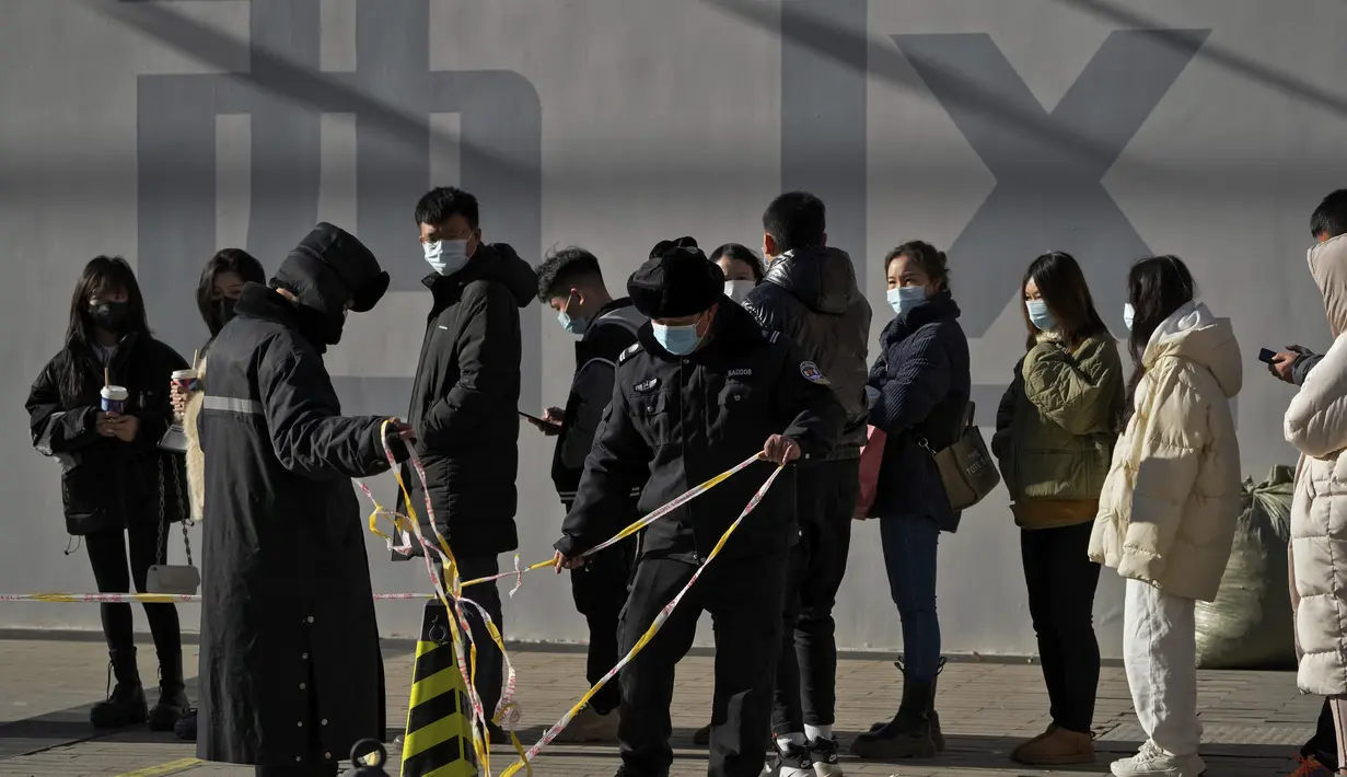Seorang wanita yang mengenakan masker beristirahat di bangku sebuah mal di Beijing (16/1/2022). Beijing telah melaporkan infeksi omicron lokal pertamanya, beberapa minggu sebelum Olimpiade Musim Dingin akan dimulai. (AP Photo/Andy Wong)