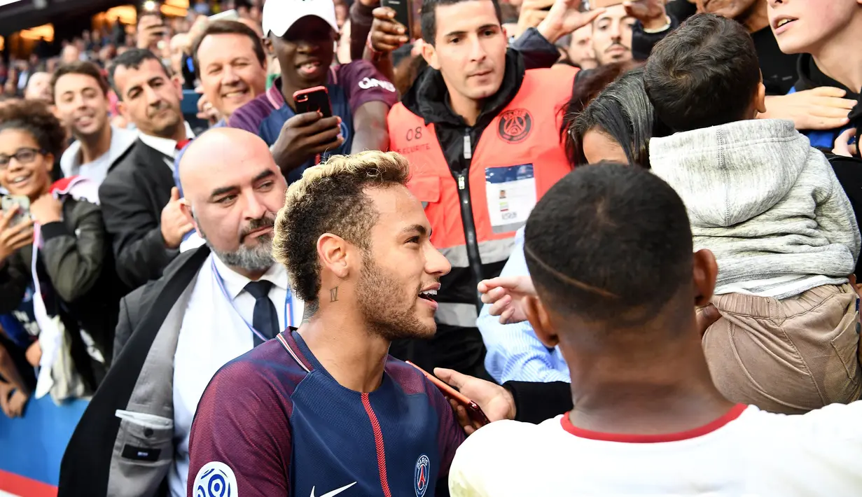 Penyerang PSG, Neymar menyapa penonton sebelum berfoto bersama usai pertandingan Ligue 1 antara PSG melawan Bordeau di stadion Parc des Princes di Paris (30/9). Dalam pertandingan ini Neymar menyumbang satu gol untuk PSG. (AFP Photo/Franck Fife)